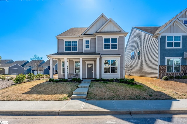 craftsman-style house with board and batten siding, a front yard, and a porch