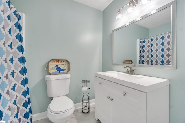 bathroom with vanity, toilet, and baseboards