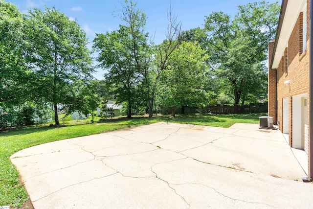 view of patio featuring a garage, concrete driveway, central AC, and fence