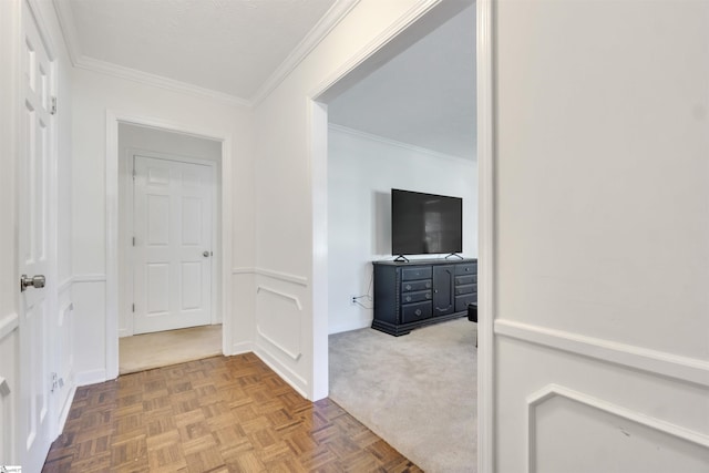 hallway featuring ornamental molding and a decorative wall