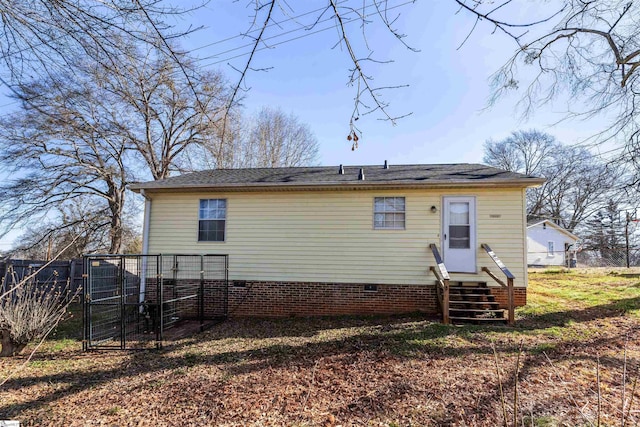 back of property with entry steps, crawl space, fence, and a gate