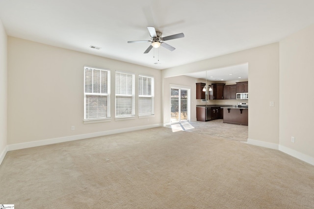 unfurnished living room featuring recessed lighting, light colored carpet, a ceiling fan, visible vents, and baseboards