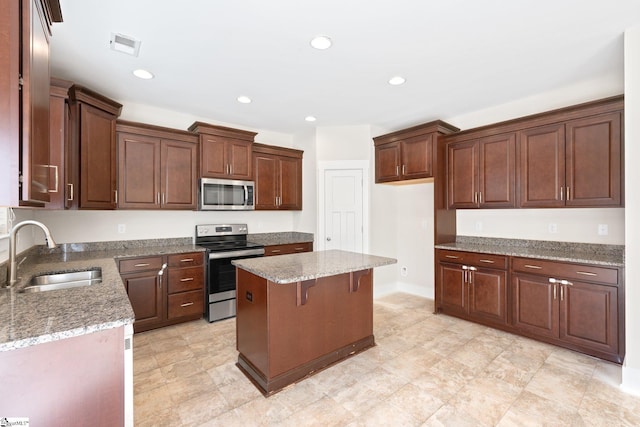 kitchen with recessed lighting, stainless steel appliances, a kitchen island, a sink, and visible vents