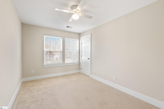 empty room featuring baseboards, visible vents, a ceiling fan, and light colored carpet