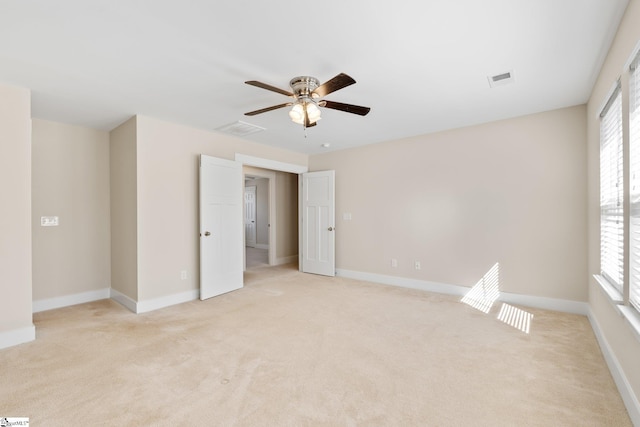 unfurnished room featuring visible vents, baseboards, and light colored carpet