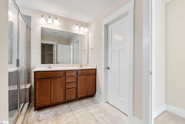 bathroom featuring double vanity, a shower stall, baseboards, and a sink