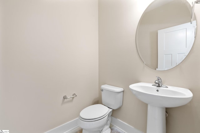 bathroom with baseboards and toilet