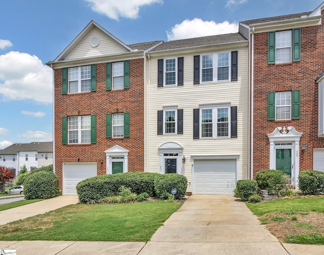 view of property featuring driveway, an attached garage, and a front yard