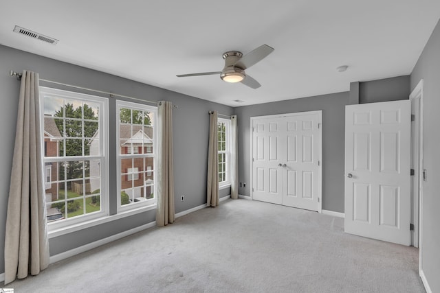 unfurnished bedroom featuring a closet, visible vents, light carpet, and baseboards