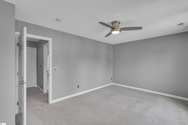 unfurnished bedroom with ceiling fan, light colored carpet, visible vents, baseboards, and attic access