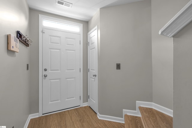 doorway featuring light wood-style flooring, visible vents, and baseboards