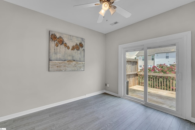 unfurnished room featuring visible vents, ceiling fan, baseboards, and wood finished floors