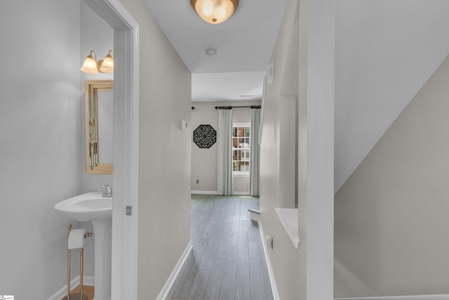 hall with baseboards and wood finished floors