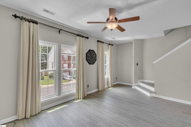 empty room with baseboards, plenty of natural light, visible vents, and light wood-style floors