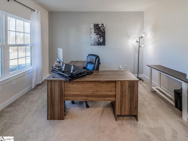 office space with baseboards and light colored carpet