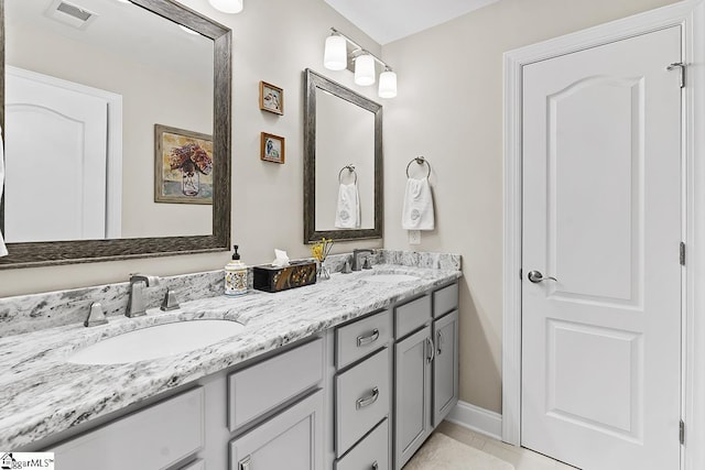 full bathroom featuring double vanity, baseboards, visible vents, and a sink