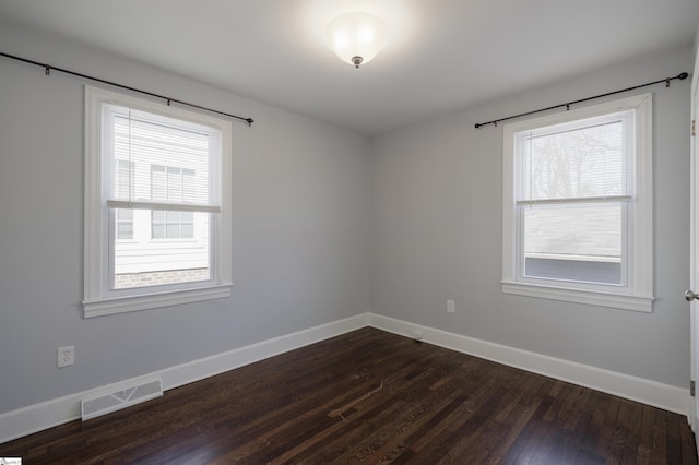 empty room featuring plenty of natural light, visible vents, and baseboards