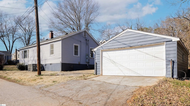 view of side of property featuring a garage, central AC unit, a chimney, an outbuilding, and crawl space