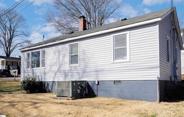 view of home's exterior featuring crawl space, a lawn, a chimney, and central AC unit