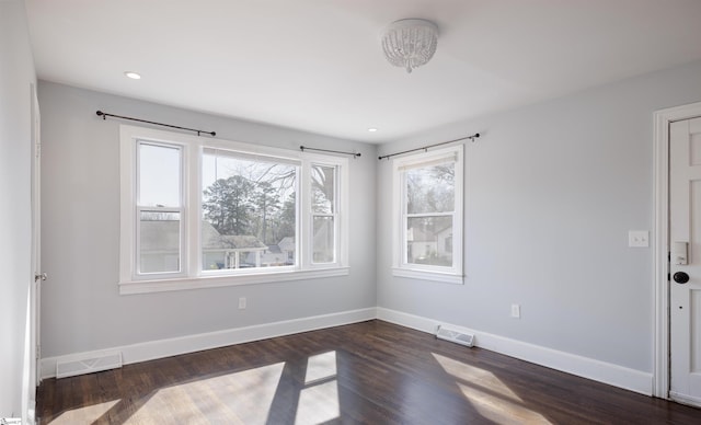 empty room featuring recessed lighting, dark wood-style flooring, visible vents, and baseboards