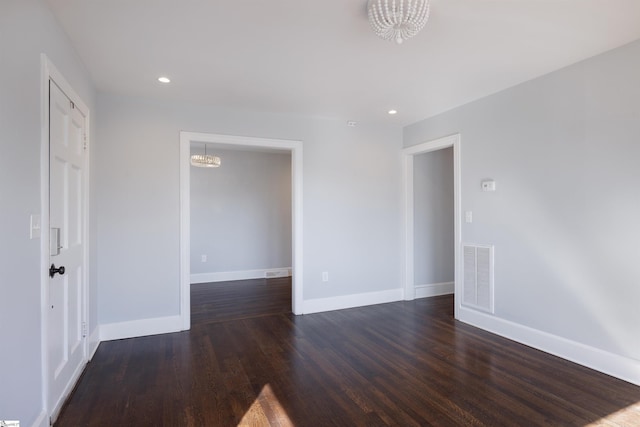 unfurnished room featuring recessed lighting, visible vents, baseboards, dark wood-style floors, and an inviting chandelier