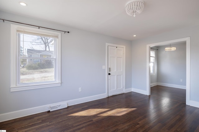 empty room featuring baseboards, visible vents, dark wood-type flooring, and recessed lighting