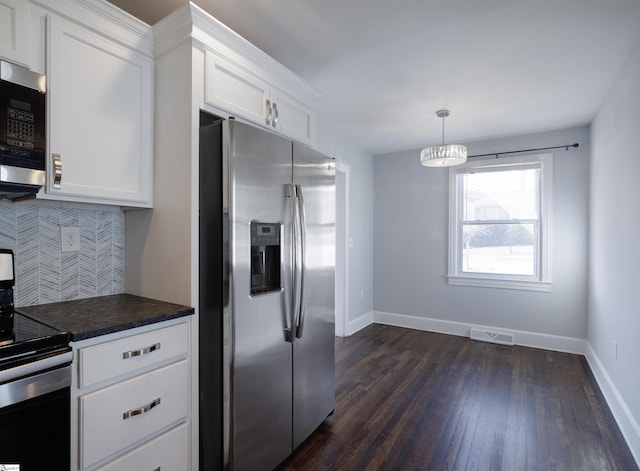 kitchen featuring tasteful backsplash, visible vents, white cabinets, dark countertops, and stainless steel appliances