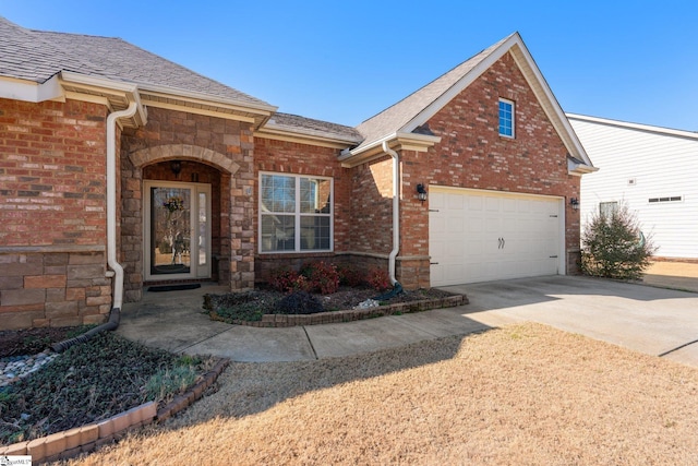 view of front of property with stone siding, a shingled roof, concrete driveway, and brick siding