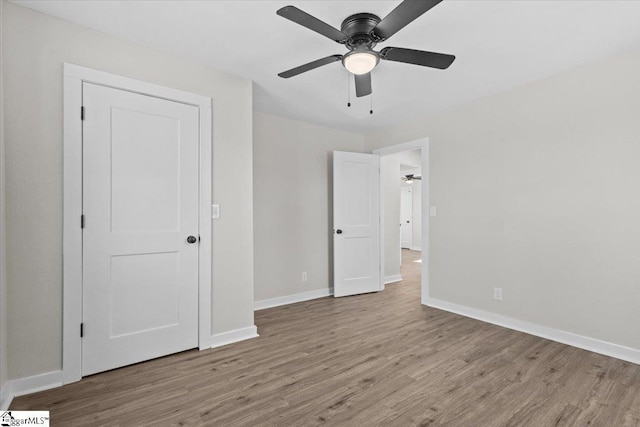 unfurnished bedroom with light wood-style floors, baseboards, and a ceiling fan