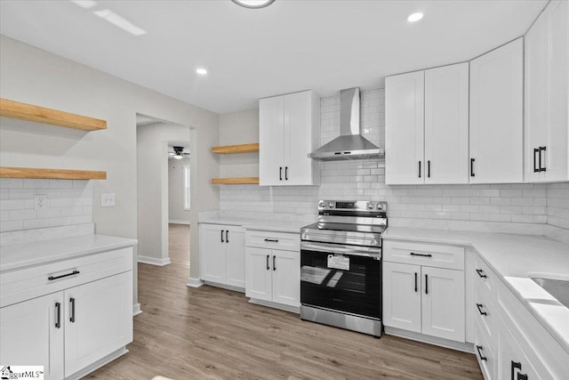 kitchen featuring open shelves, stainless steel electric stove, light countertops, white cabinetry, and wall chimney exhaust hood