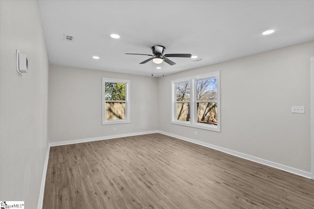 empty room featuring visible vents, baseboards, and wood finished floors