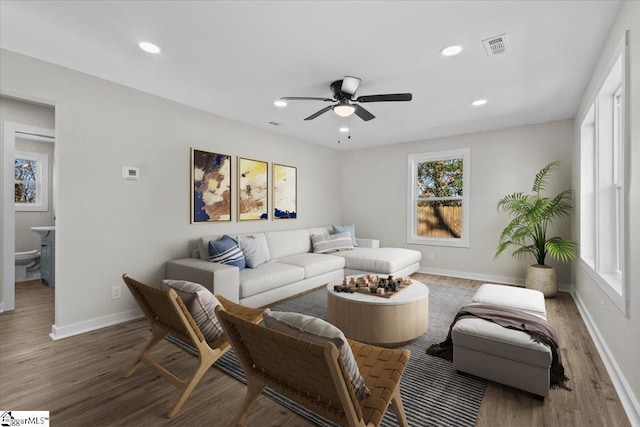 living room featuring recessed lighting, dark wood finished floors, and baseboards