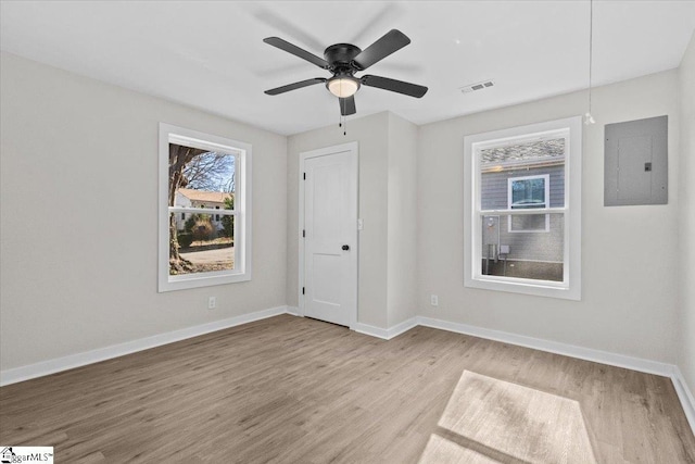 unfurnished bedroom with baseboards, electric panel, visible vents, and light wood finished floors