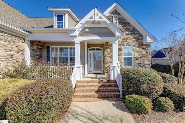 property entrance featuring stone siding and covered porch