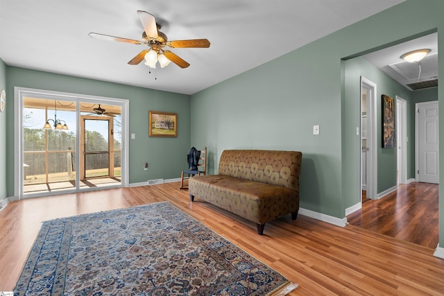 sitting room featuring attic access, baseboards, and wood finished floors