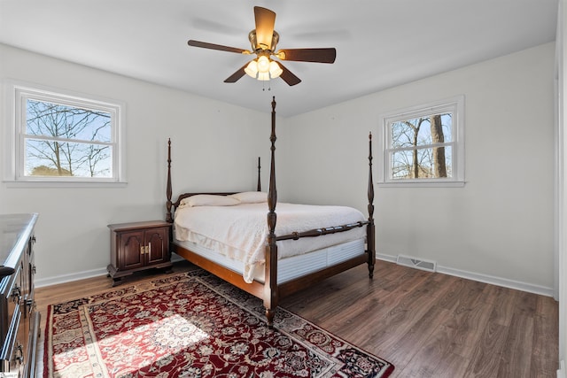 bedroom featuring visible vents, ceiling fan, baseboards, and wood finished floors