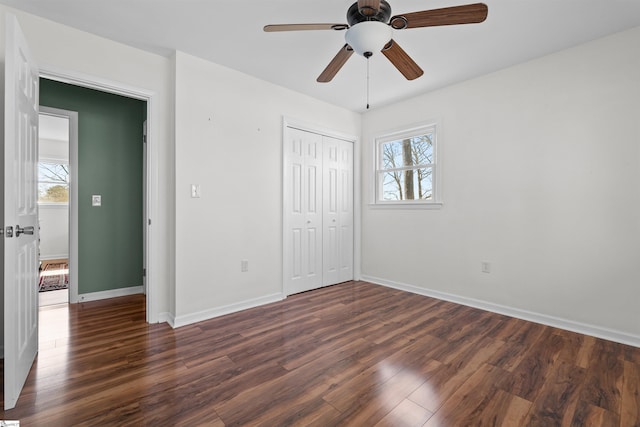 unfurnished bedroom with a closet, ceiling fan, baseboards, and wood finished floors