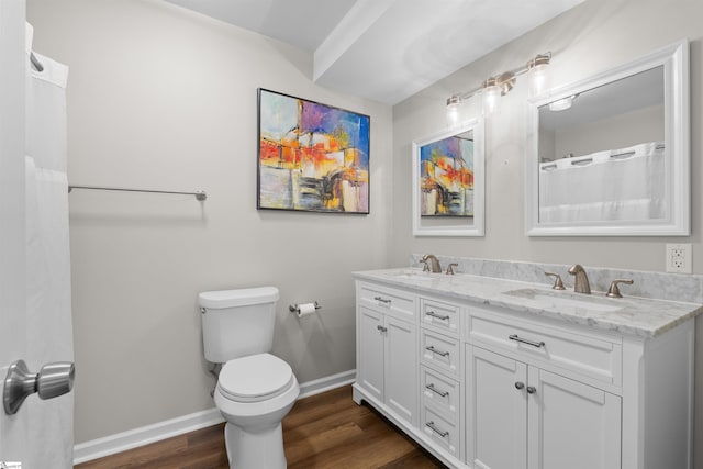 full bath with toilet, baseboards, a sink, and wood finished floors