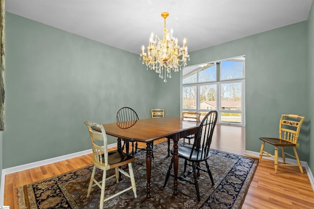 dining area featuring an inviting chandelier, wood finished floors, and baseboards