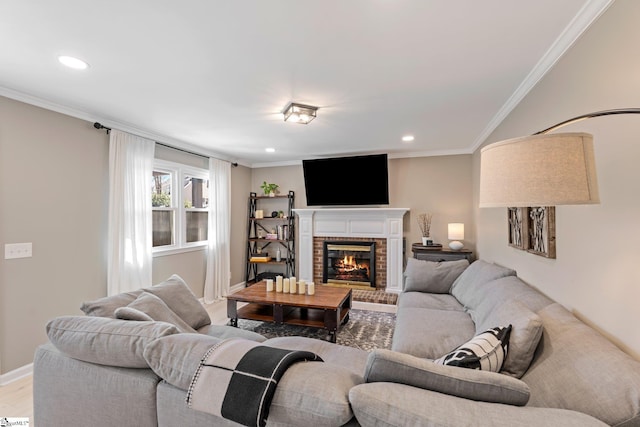 living area featuring ornamental molding, a brick fireplace, and wood finished floors