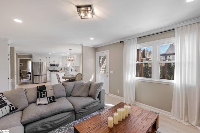 living area with light wood-type flooring, baseboards, ornamental molding, and recessed lighting