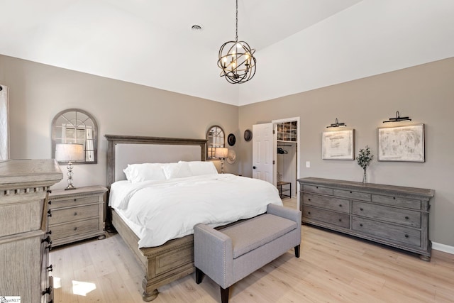 bedroom with a notable chandelier, visible vents, a spacious closet, light wood-style floors, and baseboards