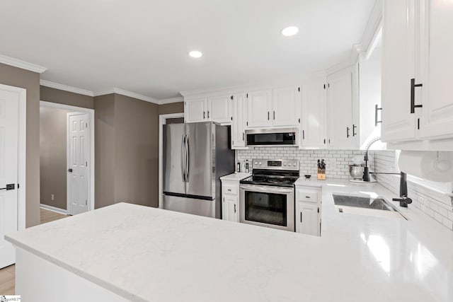 kitchen with appliances with stainless steel finishes, white cabinets, ornamental molding, and decorative backsplash