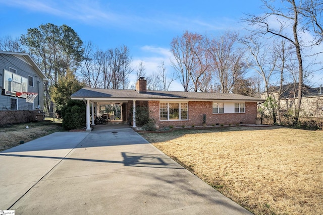 ranch-style house with concrete driveway, an attached carport, a chimney, and brick siding