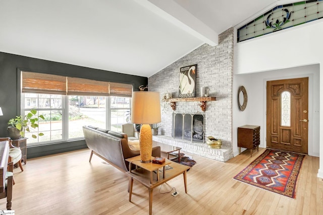 living room with a fireplace, high vaulted ceiling, wood finished floors, and beamed ceiling