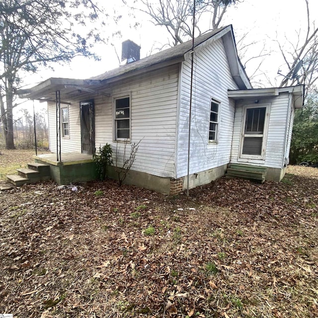 view of home's exterior featuring crawl space and a chimney