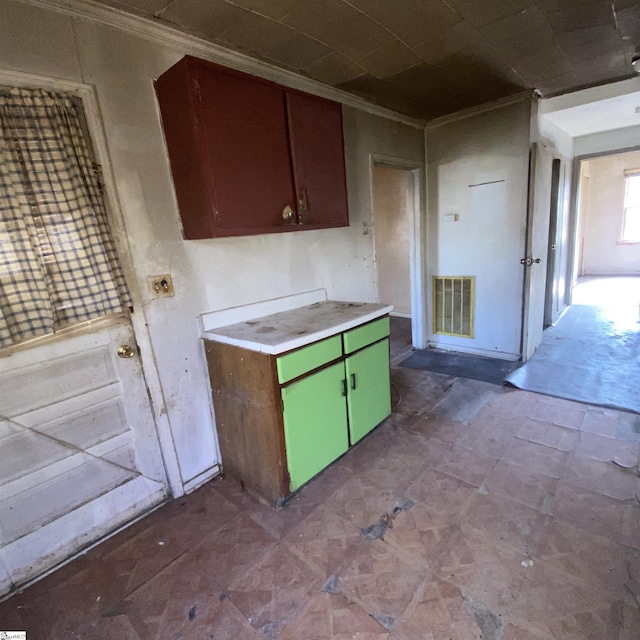 kitchen with light countertops, visible vents, and crown molding