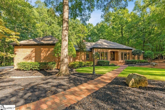 view of front of home featuring brick siding and a front yard