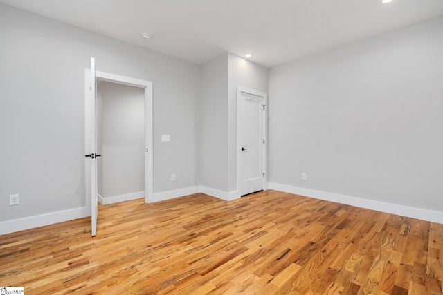 unfurnished bedroom featuring recessed lighting, light wood-style flooring, and baseboards