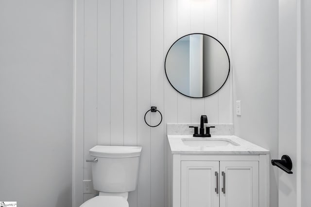 half bath featuring toilet and vanity